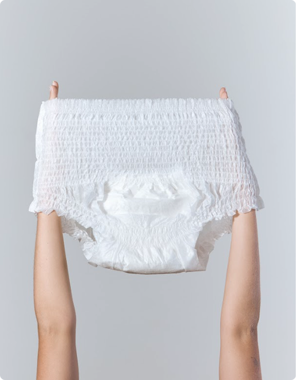 Front view of white Svelte pull-up continence underwear held open against a light grey background
