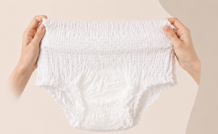 Svelte pull-up continence underwear held at the waistband against a beige background